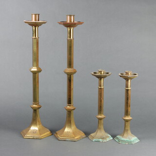 Two pairs of hexagonal gilt metal ecclesiastical candlesticks 57cm h x 15cm w x 14cm d and 30cm h x 12cm w x 10cm d 
