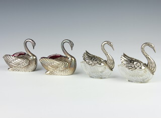 A pair of silver plated salts in the form of swans with cranberry glass liners 9cm together with a pair of plated mounted moulded glass ditto 8cm 