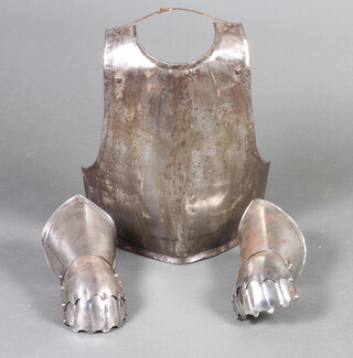 A Victorian reproduction 17th Century breastplate 44cm x 36cm together with a pair of 20th Century reproduction polished steel gauntlets 30cm x 13cm 