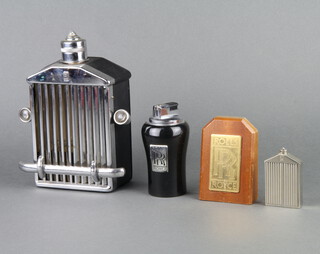 A musical flask in the form of a Rolls Royce grill, playing How Dry Am I (mascot missing) 21cm x 15cm x 7cm, a plastic table lighter marked Rolls Royce, paperweight in the form of a Rolls Royce radiator 7cm x 4cm x 2cm and a rectangular gilt metal plaque with Rolls Royce badge 10cm x 7cm x 3cm 