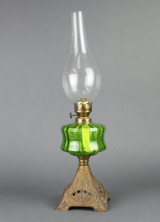 A Victorian green glass oil lamp reservoir raised on a pierced metal base with complete with clear glass chimney 51cm h x 12cm w x 12cm d 