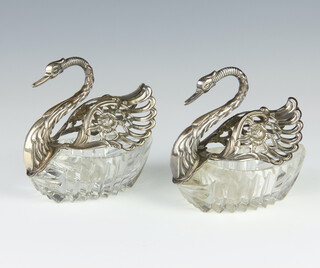 A pair of silver mounted cut glass table salts in the form of swans 11cm 