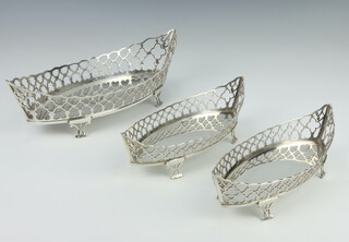A set of 3 silver boat shaped pierced bowls on scroll feet 26cm and 20cm, London 1914, 572 grams 