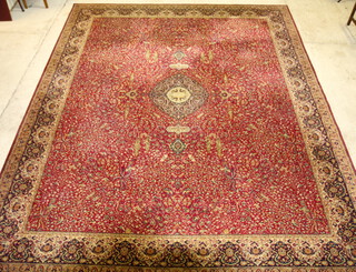 A red and white machine made floral patterned Persian style rug with central medallion 355cm x 275cm 