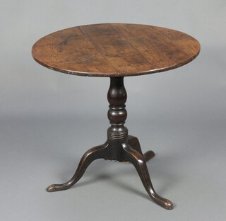 A 19th Century circular oak snap top tea table raised on a turned column and tripod base 68cm h x 74cm diam. 