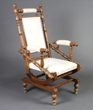 A 19th Century oak American rocking armchair with turned decoration, upholstered seat and back 114cm h x 56cm w x 51cm d (seat 24cm x 37cm) 