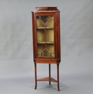 An Edwardian inlaid mahogany corner cabinet with raised back, fitted shelves enclosed by astragal glazed panelled doors, raised on outswept supports with undertier 152cm h x 38cm w x 54cm d 