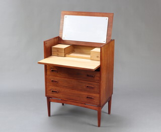 Mogens Kold, a 1950's Danish teak vanity chest. The flip top having a mirror en verso revealing a bleached interior consisting centre tray flanked left and right by two drawers and one drawer respectively. The chest of 3 long drawers with recessed handles with two faux drawers above incorporated in the fall front. Raised on round tapering legs with figured stretcher, 67w x 40d x 89h