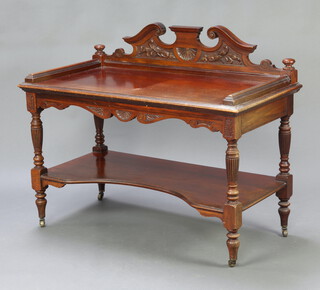 A Victorian carved walnut two tier buffet with shaped raised back, raised on turned supports with brass caps and casters 98cm h x 121cm w x 61cm d 