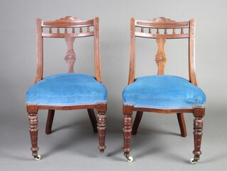 A pair of late Victorian carved walnut slat and bar back dining chairs with bobbin turned decoration and over stuffed seats, raised on turned supports 85cm h x 50cm w x 47cm d 