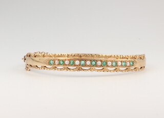 A 9ct yellow gold emerald and seed pearl bangle, 15.7 grams gross, 57mm diam. 5mm deep  