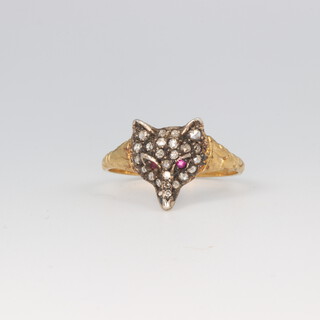 An Edwardian style yellow metal fox head ring, decorated with diamonds and ruby set eyes, size Q, 2 grams 