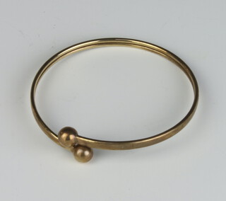A 9ct yellow gold sprung bangle with steel interior 