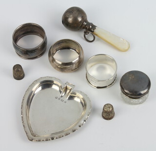 An Edwardian silver dish in the shape of a heart Birmingham 1904, 3 napkin rings, 2 thimbles, a lidded jar and rattle, weighable silver 106 grams 