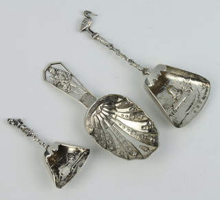 A 19th Century Continental white metal caddy spoon with a figural handle, 2 others with repousse decoration 70 grams 