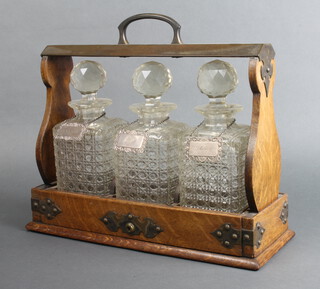 An Edwardian silver plated mounted oak 3 bottle tantalus with silver labels 