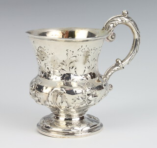 A Victorian repousse silver baluster mug with fancy scroll handle decorated with flowers, London 1861, 118 grams, 8cm 