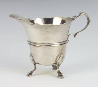 A silver cream jug with ribbed decoration on shell knees and hoof feet London 1906, 70 grams, 17cm 