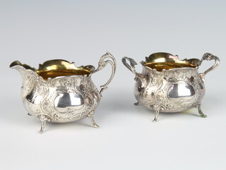 A Swedish silver cream jug and sugar with floral decoration and vacant cartouches and gilt interiors on scroll feet 186 grams 