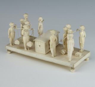 A late 19th Century carved ivory group of figures attending to a seated gentleman raised on a rectangular plinth 20cm 