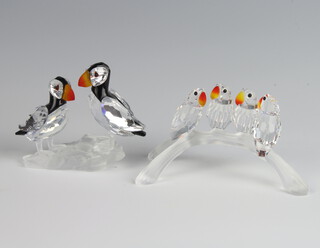 A Swarovski Crystal group of 2 puffins 6cm, a ditto of 4 parrots on a branch 9cm 