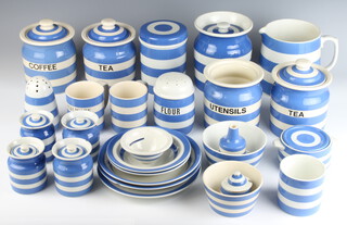 A quantity of T G Green & Co blue and white Cornish kitchenware comprising a large jug, a lidded jar and cover, a jar (chipped), a flower shaker (cracked), a jar (no lid), a jar with lid, ditto (chipped), a deep bowl, 2 dessert bowls, 3 soup bowls (1 chipped), a condiment and a bowl (all green mark), a sugar shaker and a cloves jar (no lid) (both with black mark), a utensils jar, a tea jar and lid, coffee jar and lid, a plain jar and lid, 2 mugs, a pot and lid, tea jar and lid, deep bowl, cake funnel, 2 lids (later mark)