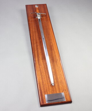 Wilkinson Sword, a reproduction double edged sword with 85cm blade marked Wilkinson Sword, on a mahogany plaque with an empty presentation plate. 