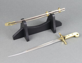 A paper knife in the form of an American Marine officer's sword, the blade etched United States Marines 28cm, on an ebonised stand 