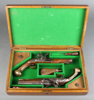 An 18th century English 18 bore flintlock pistol by Griffin, together with a similar by Barber.  Both pistols stamped London view and proof mark with makers mark in between having brass butt caps and engraved escutcheons ("No. 1" on the Barber, "JM" on the Griffin), both with walnut stocks and replacement ramrods, (some damage to each stock).  The later made up case containing a copper and brass powder flask and two turn screws 