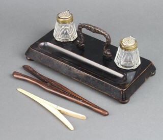 A Victorian rectangular ebonised twin bottle inkstand with pen receptacle fitted 2 cut glass bottles with hinged lids, raised on bun feet 9cm x 26cm x 13cm together with a pair of bone glove stretchers and wooden ditto 