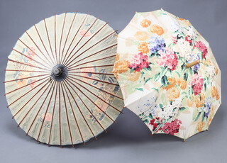A bamboo and paper parasol together with a cloth parasol 