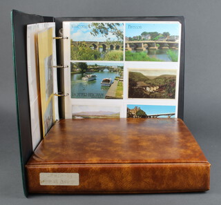 Two ring bound albums of black and white and coloured postcards including topographica, bridges, band stands, fountains and village scenes 