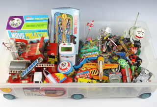 A large collection of tinplate clockwork and other toys contained in a rectangular plastic crate 
