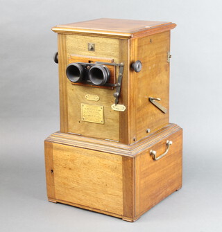 A French automatic stereoscopic viewer "Le Taxiphote" by Jules Richard circa 1905, the twin handled storage base fitted three long drawers each of 4 compartments containing a Bakelite magazine holding 25 slides, the upper cased mechanism fully functional and features a wooden slide ocular adjuster 41 cm h x 22 cm w (including storage base)

The 12 slide trays to include subjects of Brighton, Surrey, Portugal, France (most involving automotive races) 
