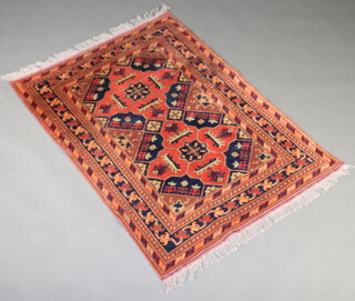 A red and blue ground Afghan rug with 2 stylised medallions to the centre within a 5 row border 151cm x 106cm 