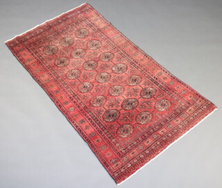A red ground Bokhara rug with 21 octagons to the centre 179cm x 97cm 