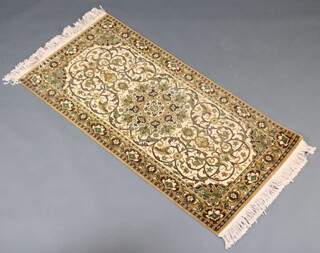 A green and white ground machine made Persian style hearth rug 141cm x 70cm 