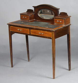 An Edwardian inlaid mahogany writing table, the arched back fitted an oval bevelled plate mirror flanked by 2 drawers with green inset writing surface, raised on square tapered supports 96m h x 86cm w x 43cm d  