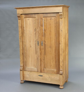 A 19th Century Continental pine wardrobe fitted a rail and shelves enclosed by panelled doors, on bun feet 177cm h x 114cm w x 54cm d
