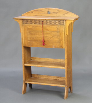 An Edwardian Art Nouveau bleached oak students bureau, the arched back with carved decoration, the fall front revealing a well fitted interior with 2 inkwells above 2 shelves 115cm h x 84cm w x 24cm d 