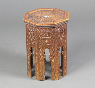 An Eastern carved octagonal hardwood table inlaid mother of pearl raised on panelled supports 40cm h x 30cm w x 30cm d 
