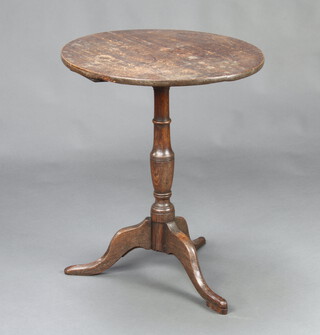An 18th/19th Century circular oak tea table, raised on a turned column and tripod base 69cm h x 56cm diam. 