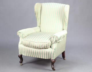 An Edwardian winged armchair upholstered in Regency stripe, raised on cabriole supports 100cm h x 74cm w x 61cm d (seat 41cm x 55cm) 