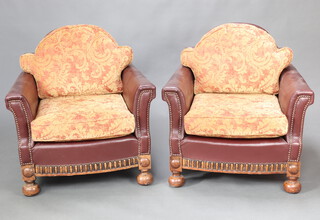 A pair of 1930's Art Deco oak framed club style armchairs upholstered in brown rexine, raised on bun supports 77cm h x 80cm w x 71cm d (seat 48cm x 39cm) 