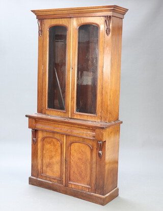 A Victorian mahogany bookcase on cabinet with moulded cornice, fitted adjustable shelves enclosed by arch panelled doors, the base fitted a drawer above cupboards enclosed by panelled doors 207cm h x 107cm w x 42cm d 