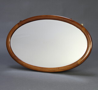 An Edwardian oval bevelled plate wall mirror contained in an inlaid mahogany frame 49cm x 79cm 