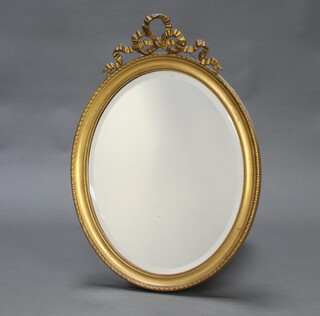 An Edwardian oval bevelled plate wall mirror contained in a decorative gilt frame surmounted by swags 67cm h x 48cm w 