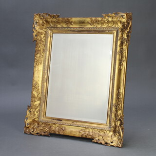 A 19th Century rectangular bevelled plate mirror contained in a decorative gilt plaster and wood frame 88cm h x 76cm w x 5cm  