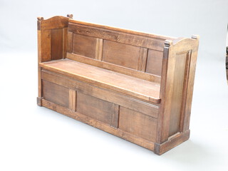 A 19th Century oak pew of panelled construction, the seat with hinged lid revealing a void 84cm h x 141cm w x 47cm d 