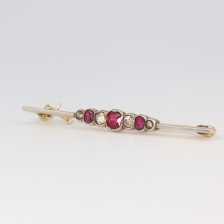 A yellow metal bar brooch set with 4 diamonds and 3 rubies, 2.6 grams, 45mm 